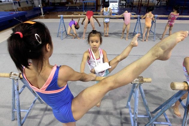 Hình ảnh một bé gái đang bị gãy tay nhưng vẫn phải tập luyện....